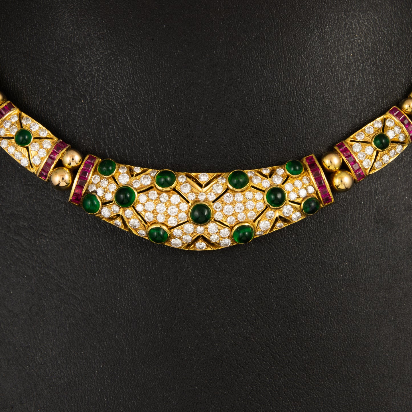 Gargantilla en oro amarillo, diamantes talla brillantes, rubís talla princesa y cabujones de esmeraldas estilo Bulgari.. Años 80.