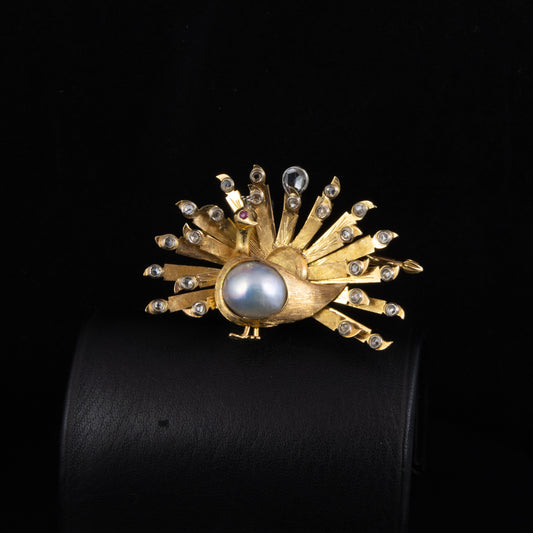 Broche en oro amarillo con diamantes y perla con figura de pavo real.
