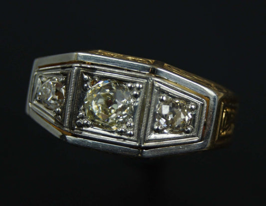 Anillo antiguo de oro y platino con 3 brillantes 1 de 0,85 y 2 de 0,25 cts. la montura con grabados.