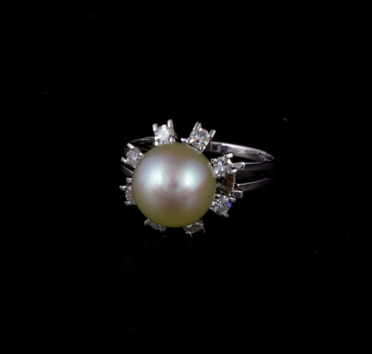 Anillo oro blanco estilo rosetón con perla central y brillantes.