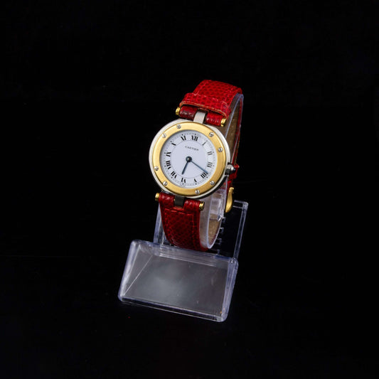 Reloj Cartier Must en acero y oro, con correa de piel roja.