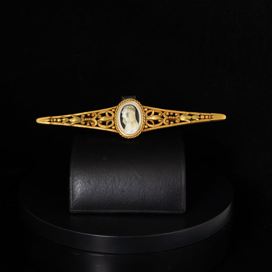 Broche de años 20, oro amarillo y figura femenina en marfil.