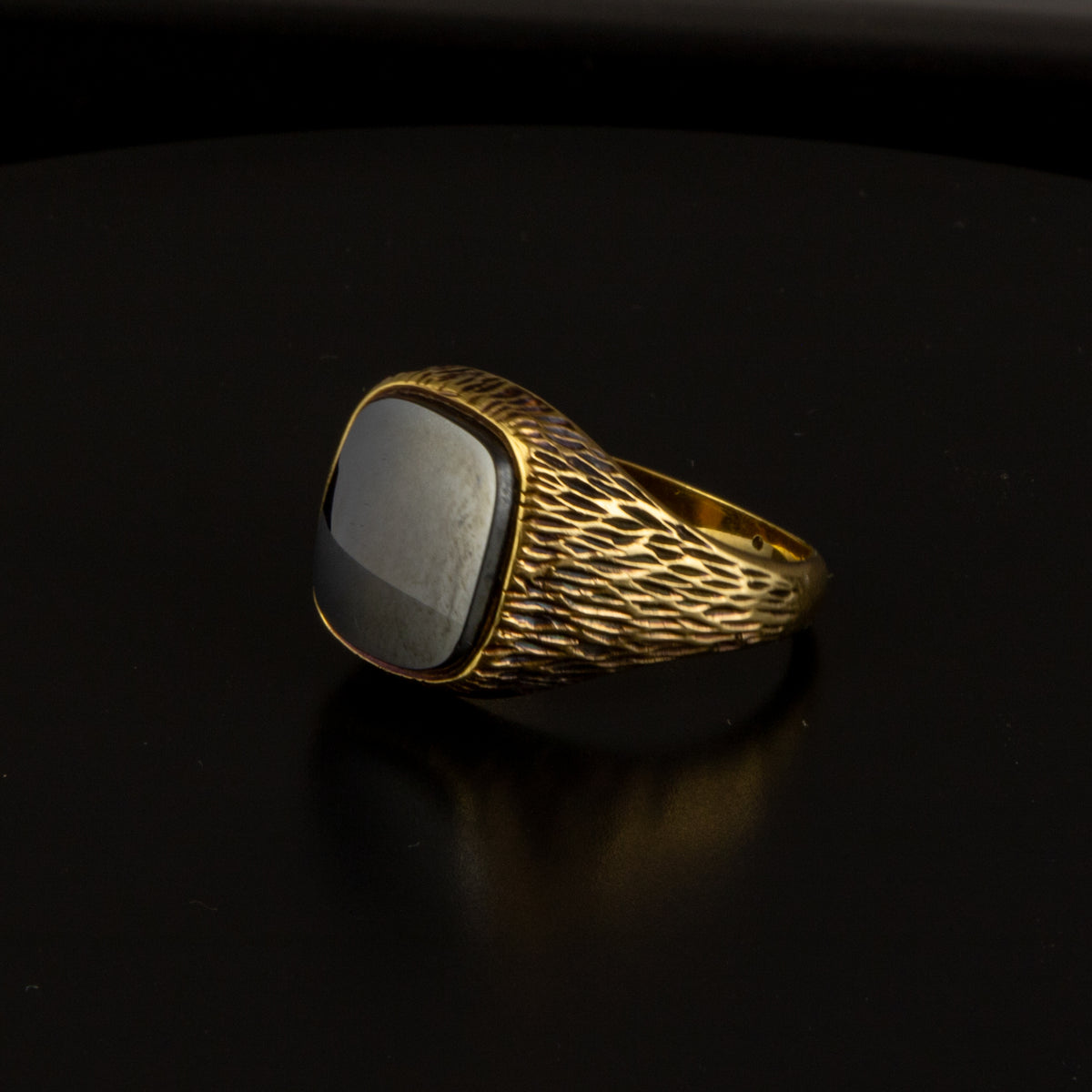 Sello en oro amarillo con piedra negra.