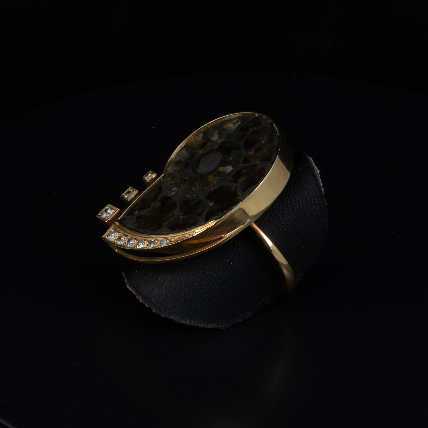 Anillo en oro amarillo con gema fosilizada y brillantes.