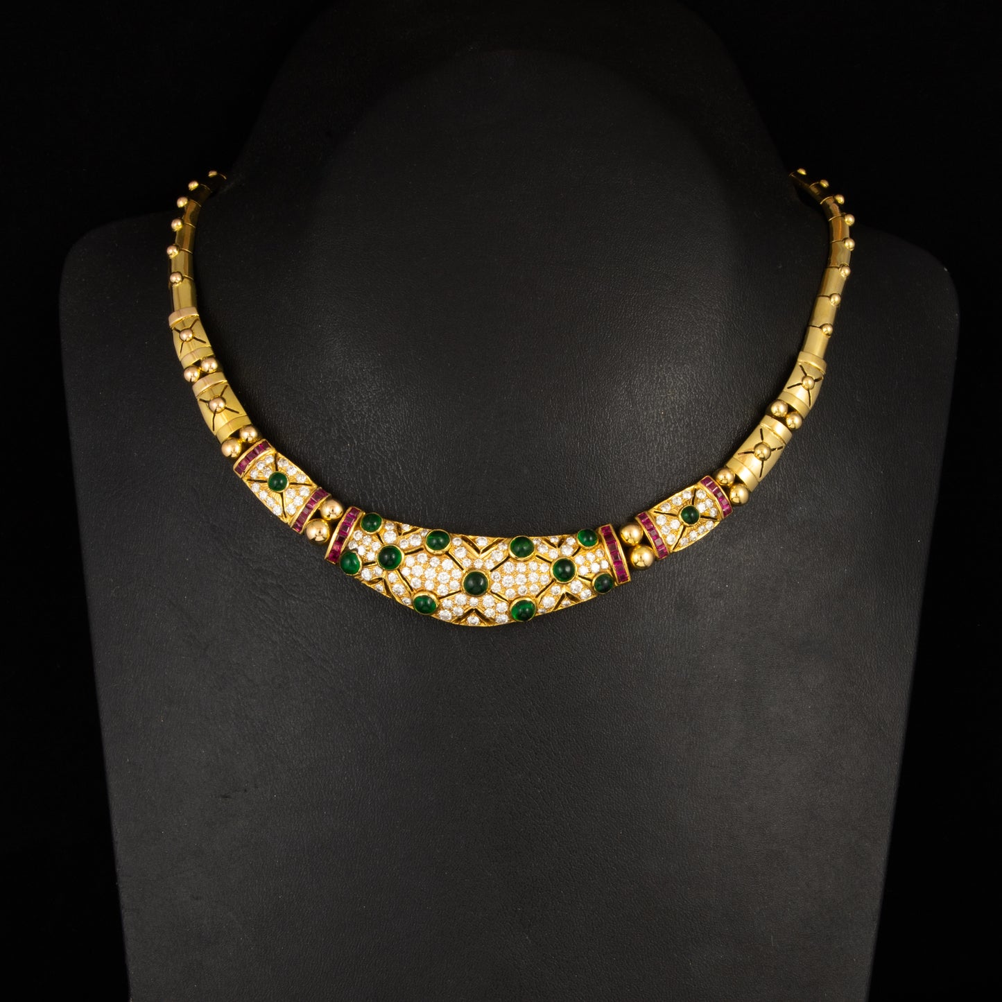 Gargantilla en oro amarillo,  diamantes talla brillantes, rubís talla princesa y cabujones de esmeraldas estilo Bulgari.. Años 80.