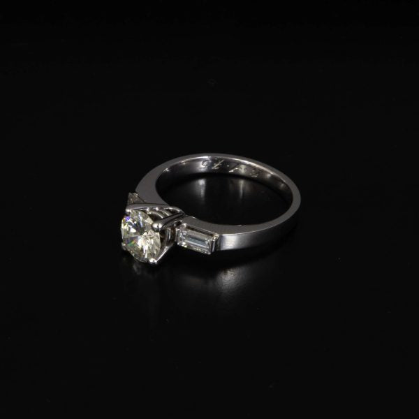 Anillo en oro blanco con brillante central de 0,94 cts. en color G VVS1 y dos taipers.